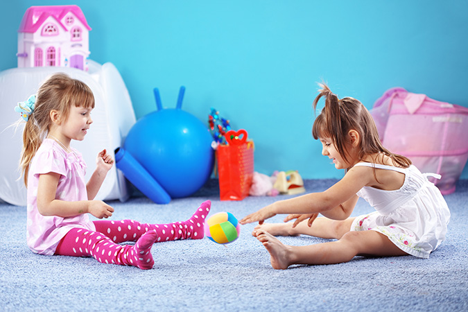 Due bambine giocano sul tappeto nella cameretta